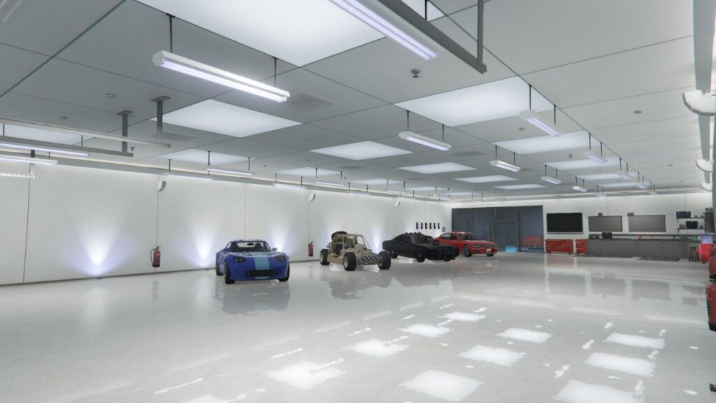 Das Innere einer gut beleuchteten High-End-Garage mit drei Sportwagen und einem Buggy.