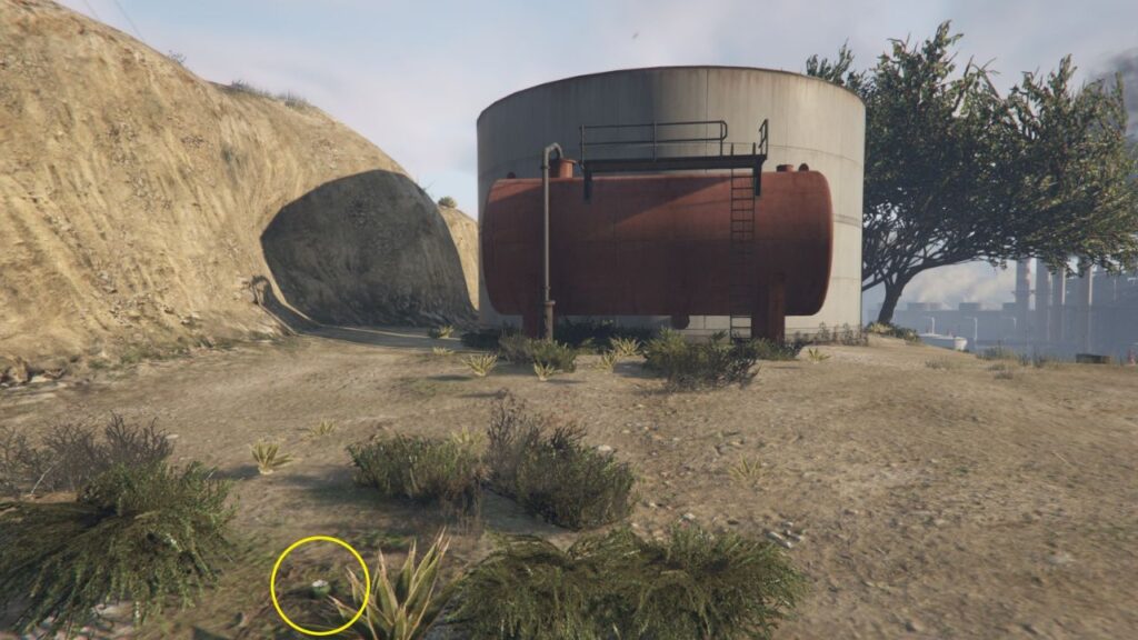 The Peyote Plant hiding in the bushes near a small white silo and a red tanker.
