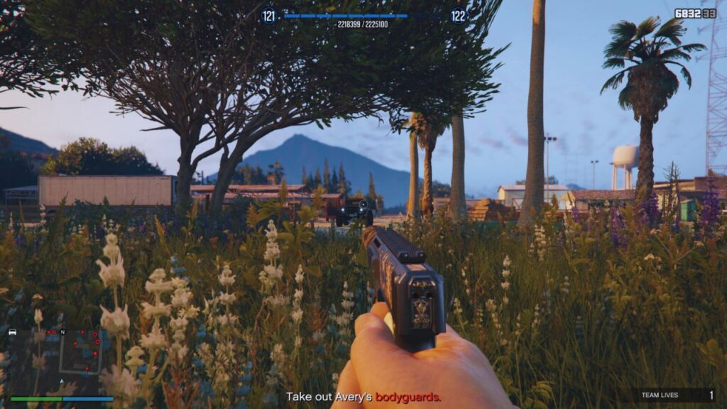 Der GTA Online Protagonist zielt mit einer schallgedämpften AP-Pistole, während er sich im Gras versteckt.